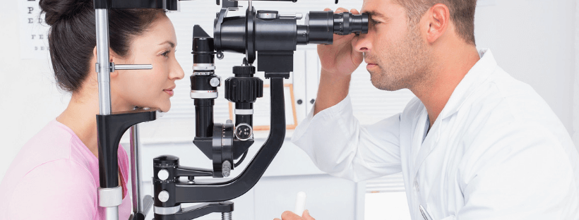 oculista esamina occhi di una paziente con macchinario