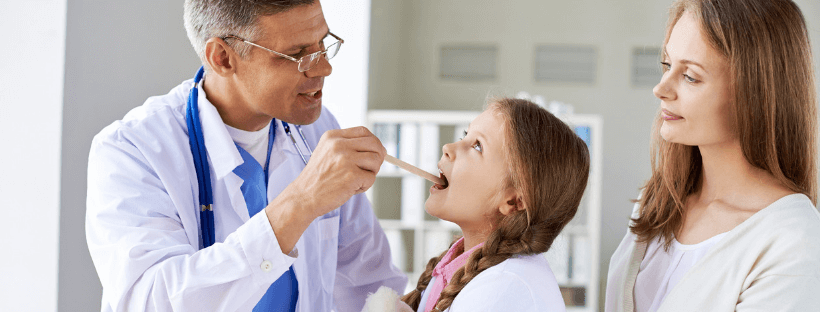 dottore controlla la gola di una bambina