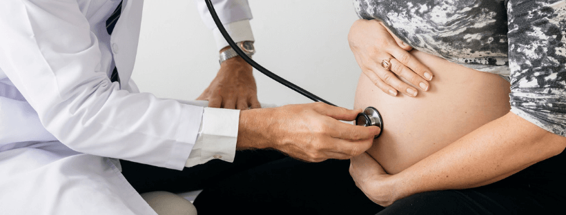Medico sente il pancione di una donna con lo stetoscopio